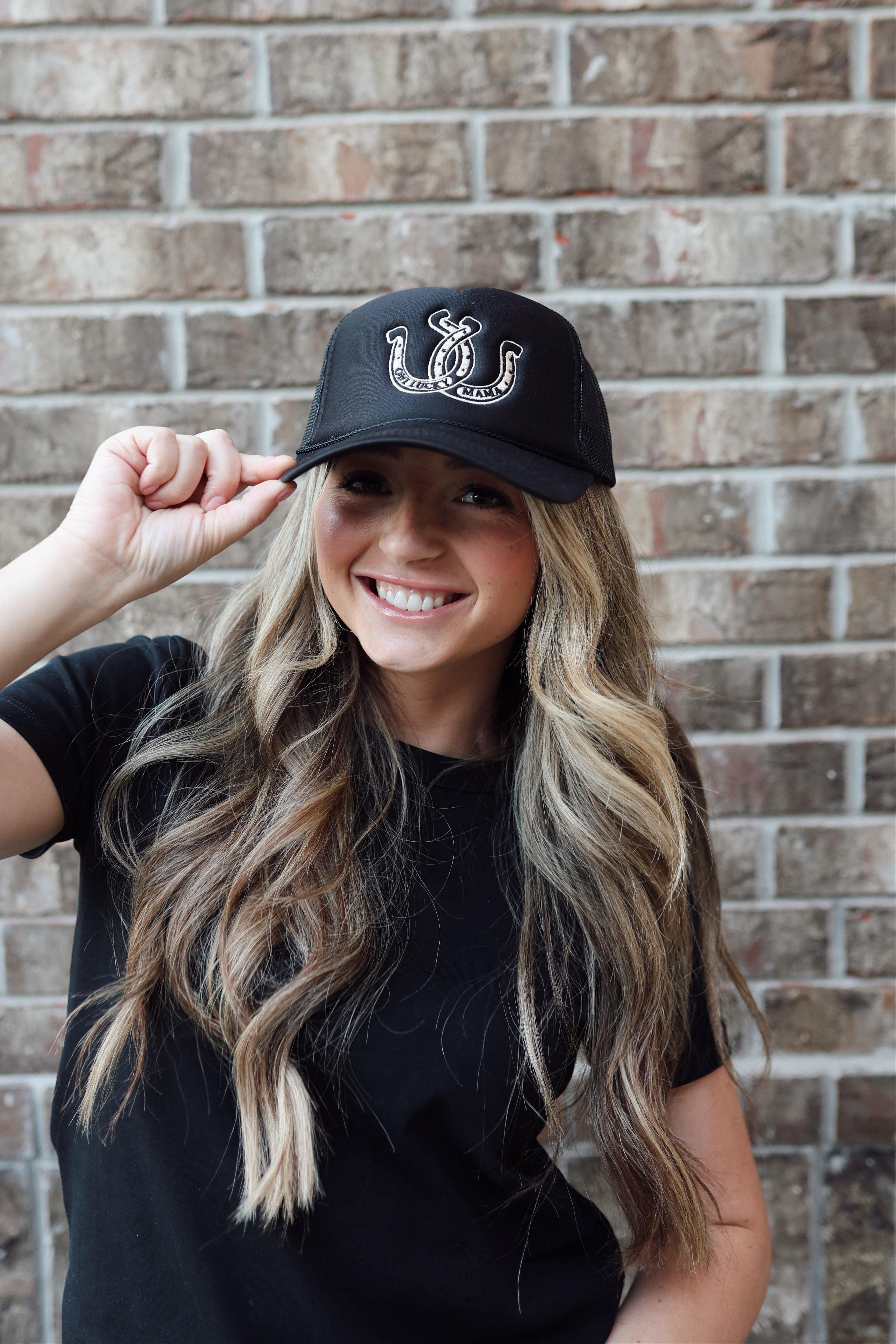 Black trucker hat for moms with an embroidered design of a horseshoe on it for moms